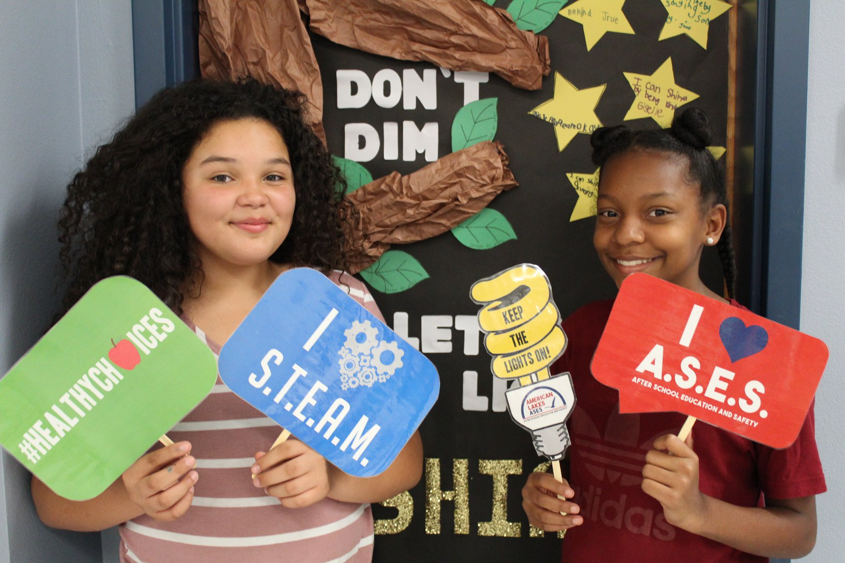 Two ALS students holding up ASES Program signs