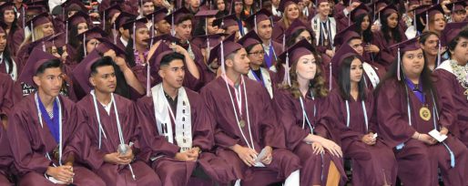 Natomas High graduates sitting at grad ceremony in their caps and gowns