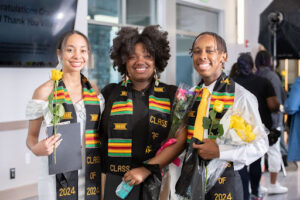 grads smiling with kente cloths during black graduation night 2024