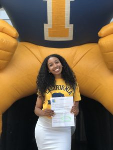 Sophanit Getahoun holding up acceptance letter to UC Berkeley in front of Inderkum blow up Tiger