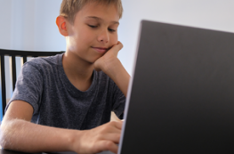 Preteen boy using laptop computer at home. Technology, online learning, distance education, home studying, homework, educational games for kids