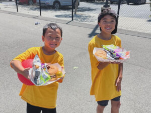 Two WRE students holding up lunches May 2024