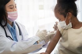 doctor giving little girl a shot in her arm